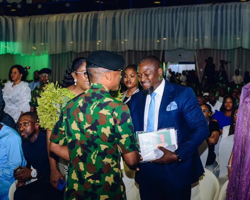 Uloko Fred in conversation with a military officer at a business summit